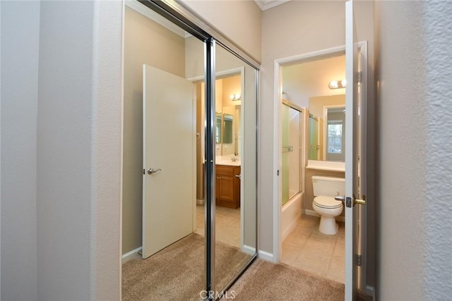 full bathroom featuring tile patterned flooring, vanity, toilet, and bath / shower combo with glass door