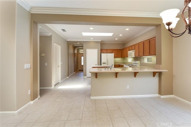 kitchen featuring white appliances, crown molding, and an inviting chandelier