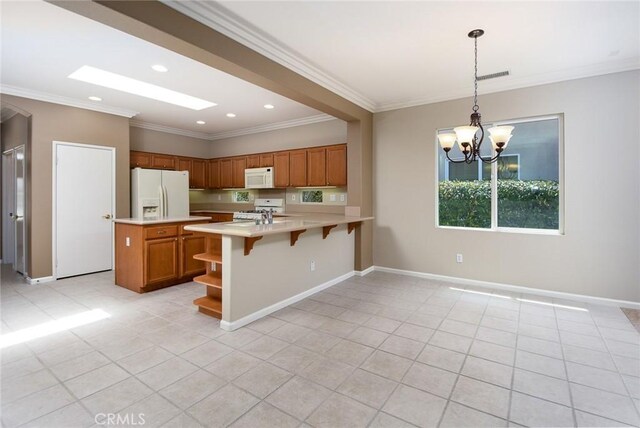 kitchen featuring white appliances, ornamental molding, light tile patterned floors, decorative light fixtures, and a chandelier