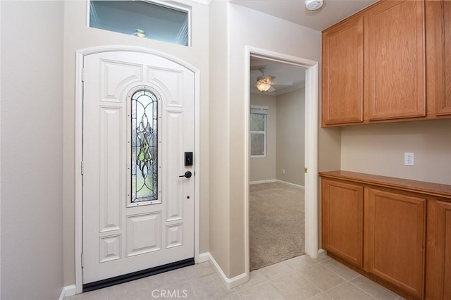 foyer entrance with ceiling fan and light tile patterned floors