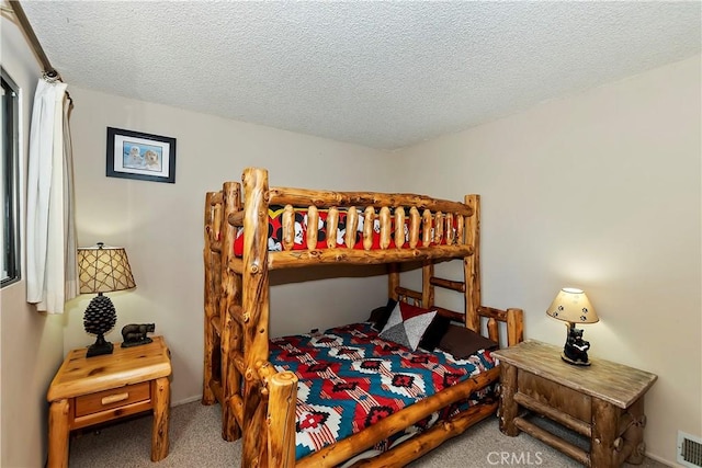 carpeted bedroom featuring a textured ceiling