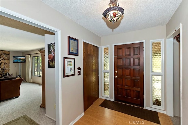 entryway featuring a textured ceiling and light hardwood / wood-style flooring