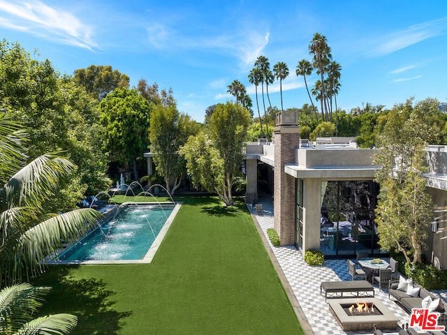 view of swimming pool featuring a fire pit, a yard, a patio, and pool water feature