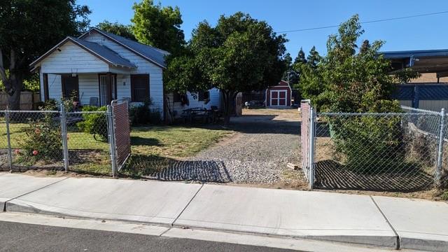 view of front of home with a front yard and a storage unit