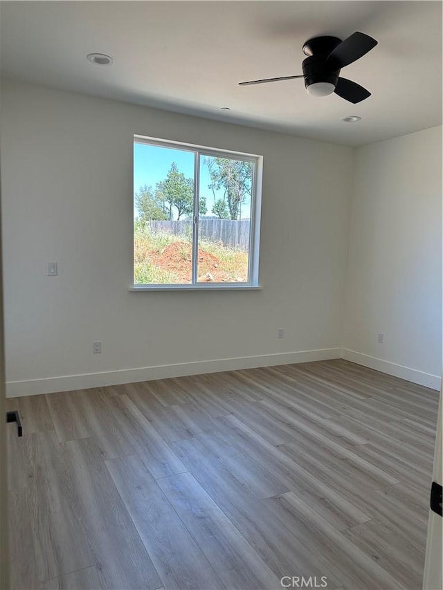 empty room featuring recessed lighting, ceiling fan, light wood finished floors, and baseboards