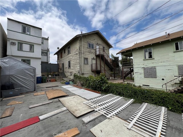 rear view of house featuring stairway and a patio area