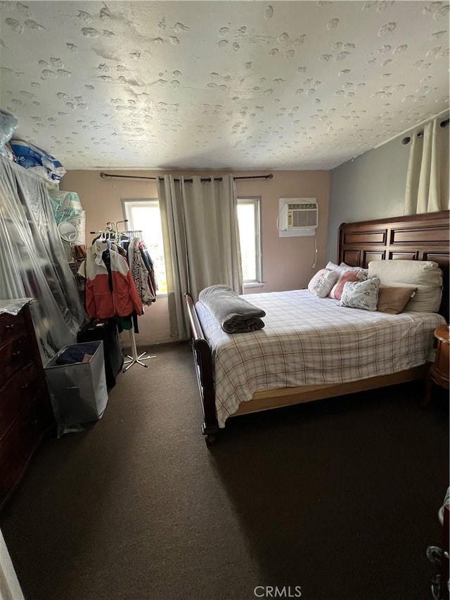 carpeted bedroom with an AC wall unit and a textured ceiling