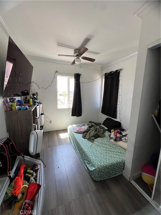 bedroom with crown molding, a ceiling fan, and wood finished floors