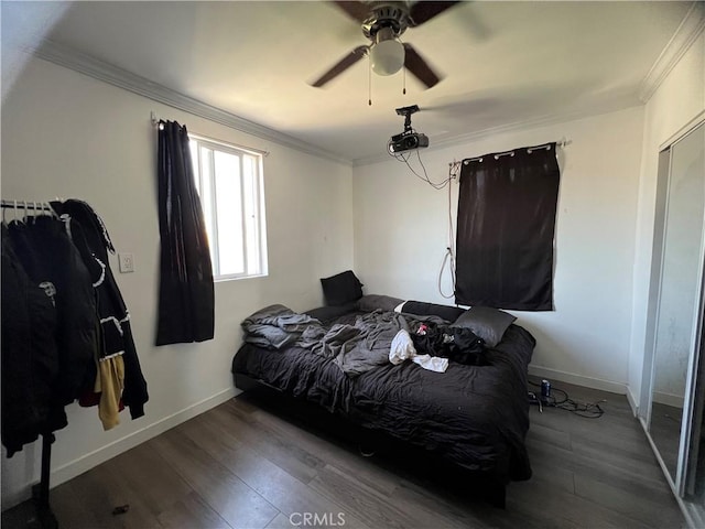 bedroom with baseboards, ornamental molding, and wood finished floors