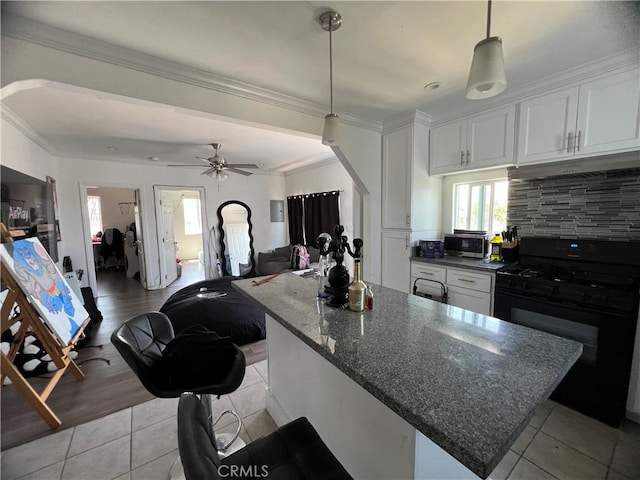 kitchen with light tile patterned flooring, white cabinets, and black gas range oven