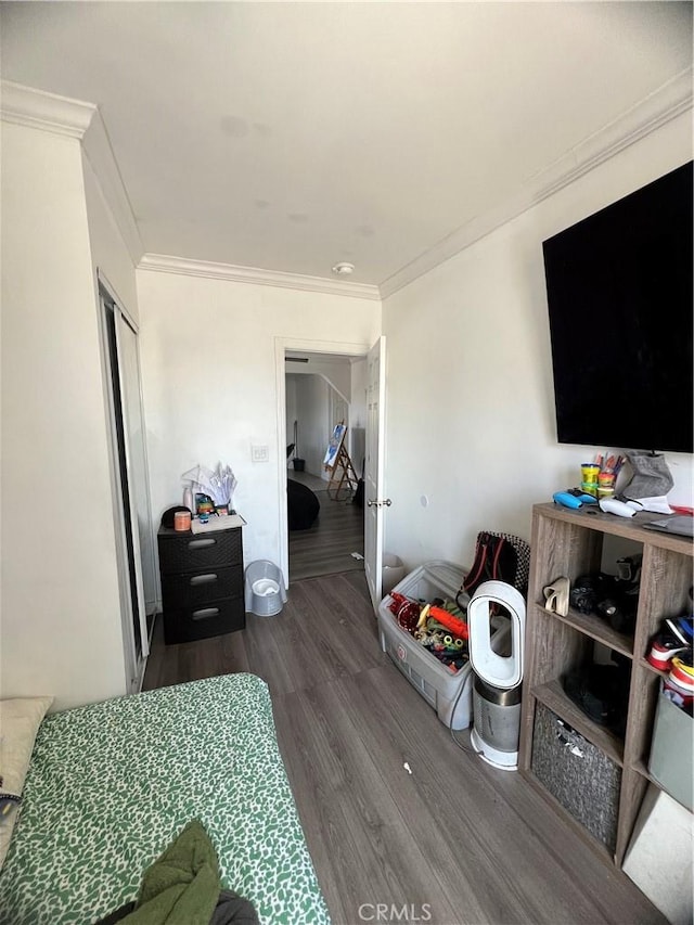 bedroom featuring ornamental molding and wood finished floors