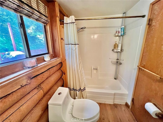 bathroom with wood-type flooring, shower / tub combo, and toilet