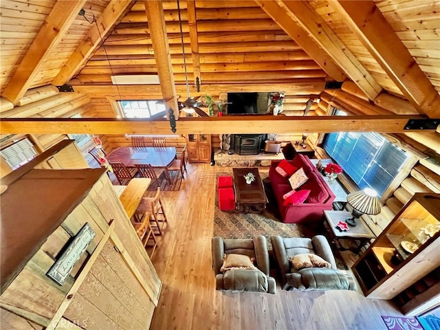 interior space with log walls, hardwood / wood-style floors, lofted ceiling with beams, and wooden ceiling