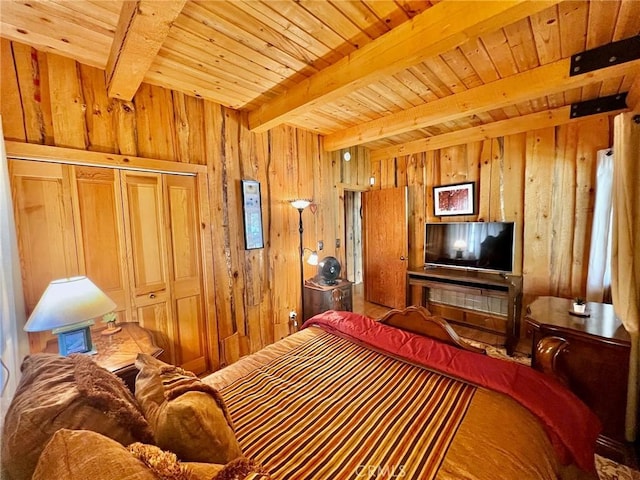 bedroom with wood walls, beam ceiling, wooden ceiling, and a closet