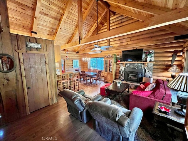 living room with wood ceiling, ceiling fan, hardwood / wood-style flooring, beamed ceiling, and a wood stove