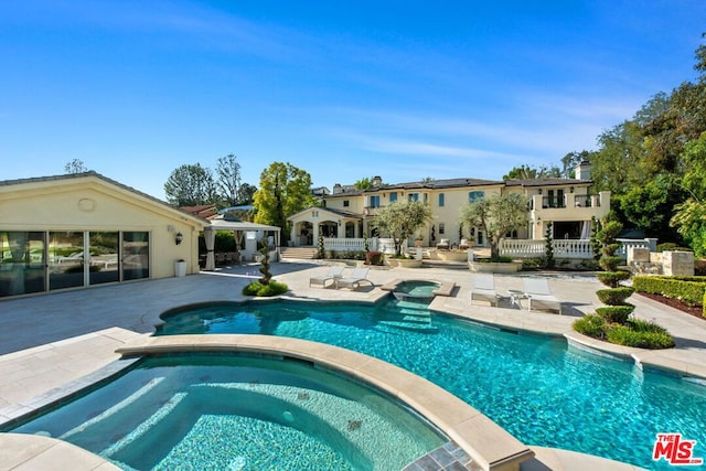 view of swimming pool with an in ground hot tub and a patio area