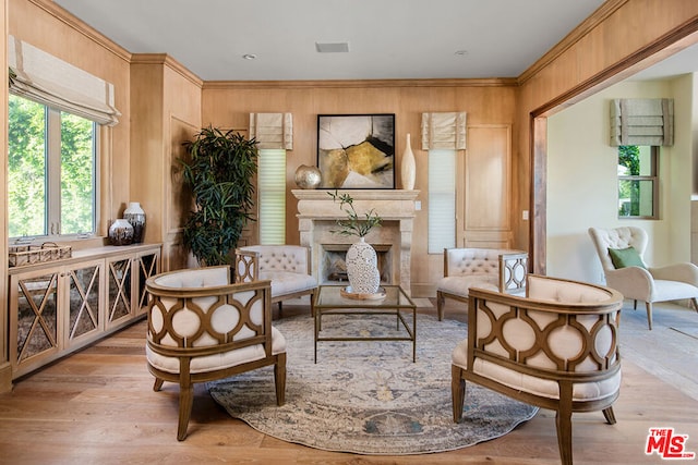 sitting room featuring light wood-type flooring, wood walls, and a fireplace