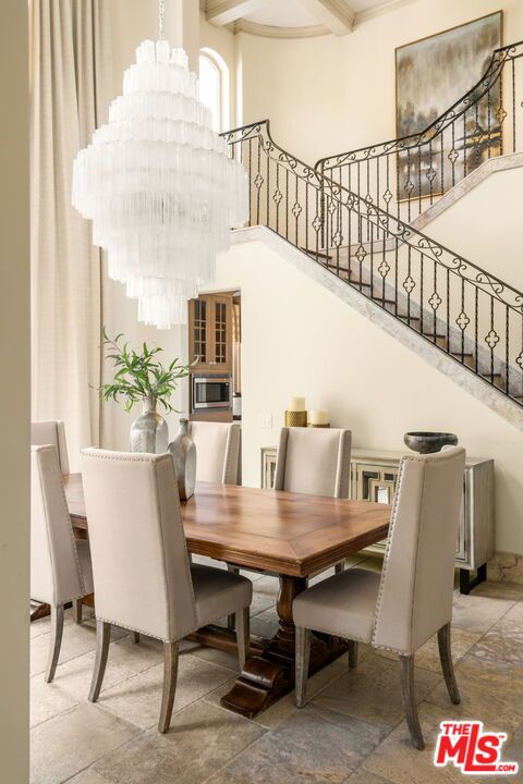 dining space with a notable chandelier, a towering ceiling, and tile patterned floors