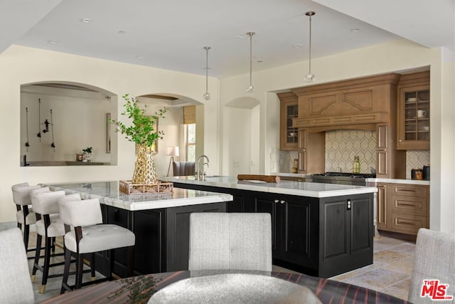 kitchen with tasteful backsplash, a kitchen island, light tile patterned floors, kitchen peninsula, and pendant lighting