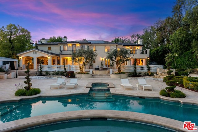 pool at dusk featuring a patio area