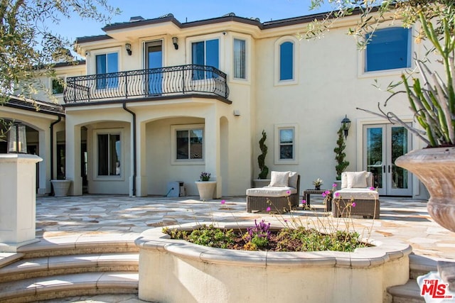 back of property featuring a balcony and a patio area