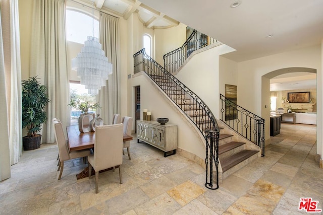 dining area featuring a healthy amount of sunlight, light tile patterned floors, and an inviting chandelier