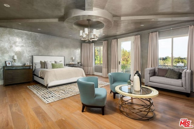 bedroom featuring an inviting chandelier, lofted ceiling, and wood-type flooring