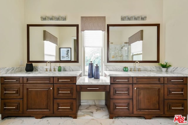 bathroom with a shower with door, vanity, and a healthy amount of sunlight