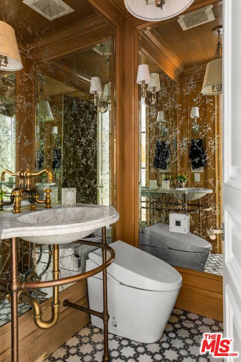 bathroom with sink, toilet, and crown molding