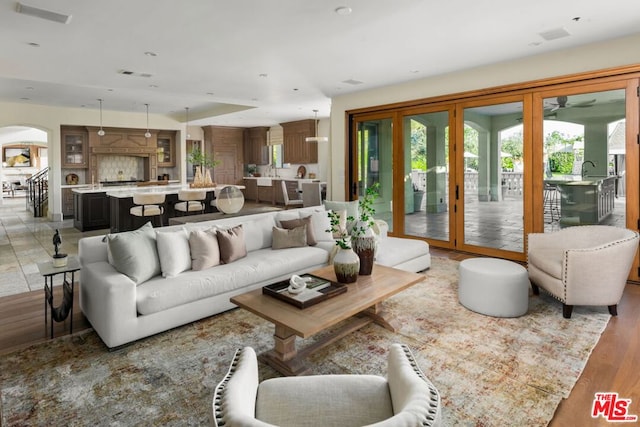 living room featuring ceiling fan, a fireplace, and light hardwood / wood-style floors