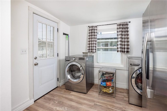 laundry room with washer / clothes dryer and light hardwood / wood-style flooring