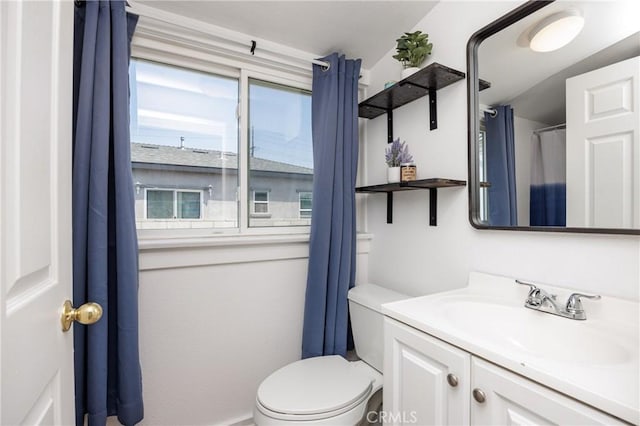 bathroom with vanity, lofted ceiling, and toilet