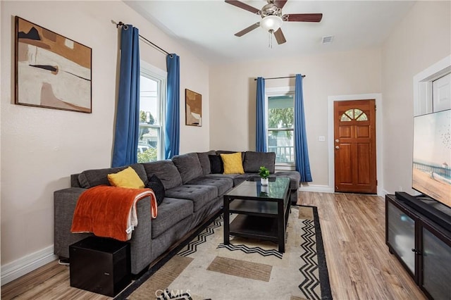 living room featuring a wealth of natural light, ceiling fan, and light hardwood / wood-style floors