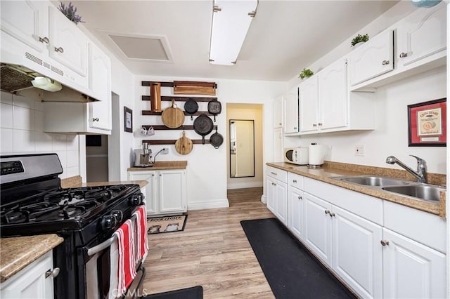 kitchen with sink, stainless steel gas range, tasteful backsplash, light hardwood / wood-style flooring, and white cabinets