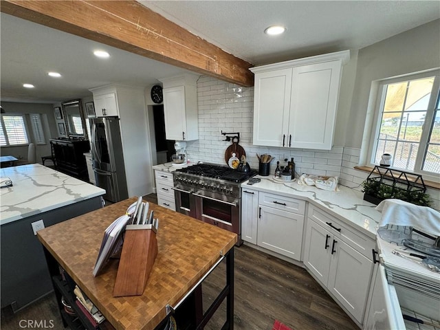 kitchen with plenty of natural light, white cabinetry, and appliances with stainless steel finishes