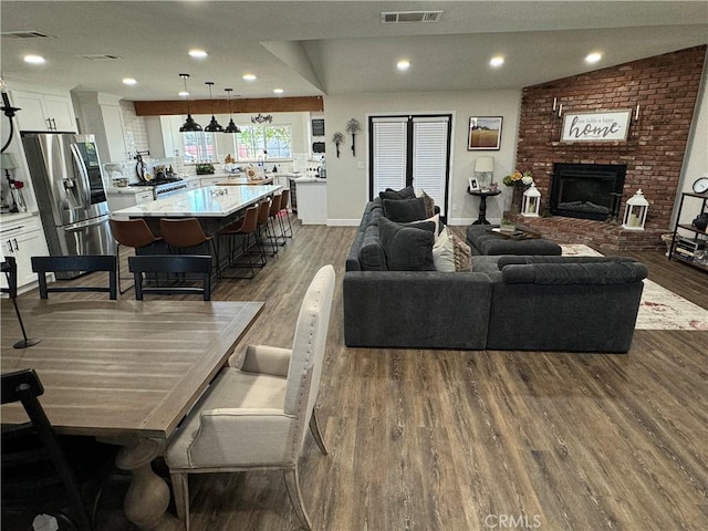 living room featuring a fireplace, dark wood-type flooring, and vaulted ceiling