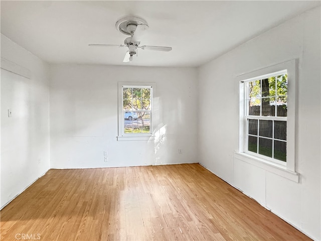 spare room featuring light hardwood / wood-style floors, ceiling fan, and plenty of natural light