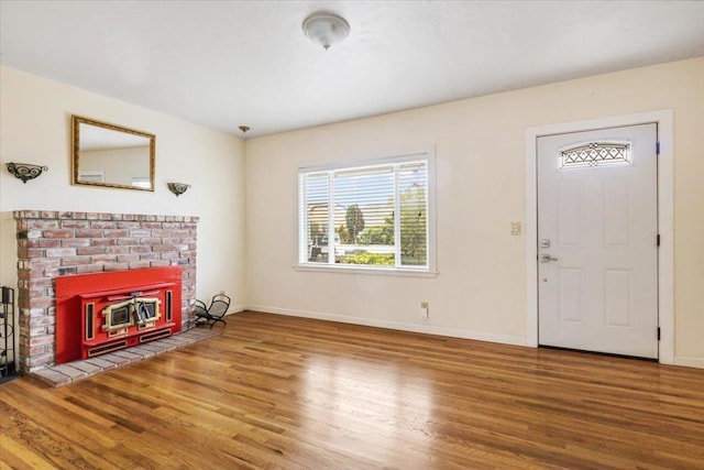 entrance foyer featuring wood-type flooring and a wood stove