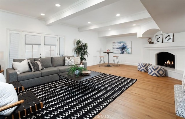 living room with beam ceiling, hardwood / wood-style flooring, and crown molding