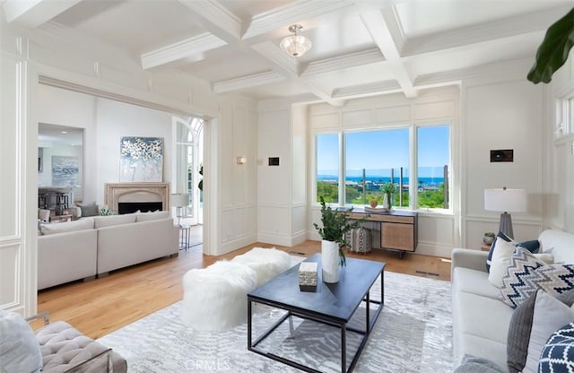 living room featuring beamed ceiling, wood-type flooring, coffered ceiling, and ornamental molding