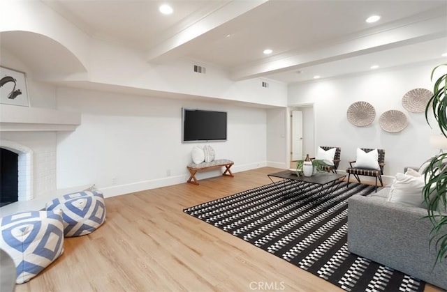 living room with a fireplace, hardwood / wood-style floors, and beam ceiling