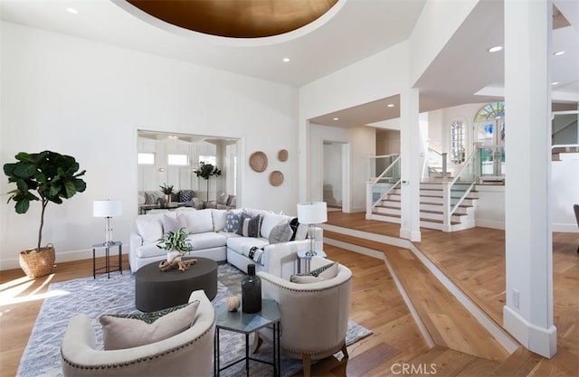 living room featuring wood-type flooring and a towering ceiling