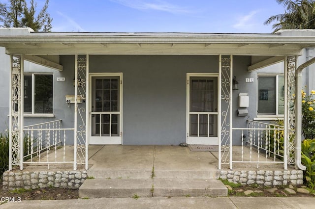 view of exterior entry featuring covered porch