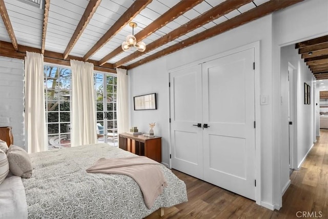 bedroom featuring hardwood / wood-style floors, wooden ceiling, a notable chandelier, a closet, and beam ceiling