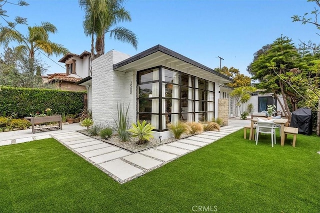 back of house featuring a lawn