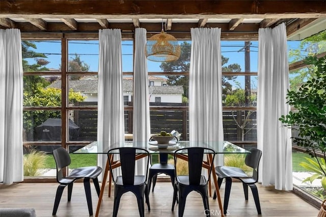 unfurnished sunroom featuring beam ceiling