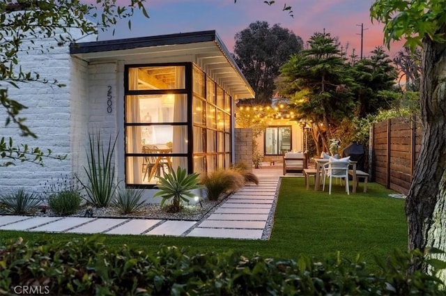 outdoor structure at dusk featuring a lawn