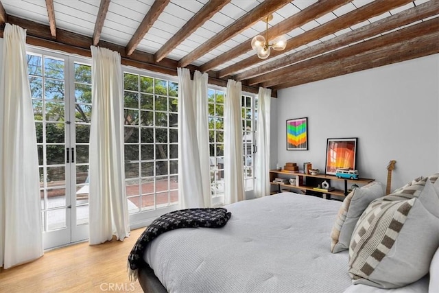 bedroom with multiple windows, light hardwood / wood-style flooring, and beam ceiling