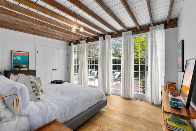 bedroom featuring a closet, wood ceiling, beamed ceiling, and light hardwood / wood-style flooring