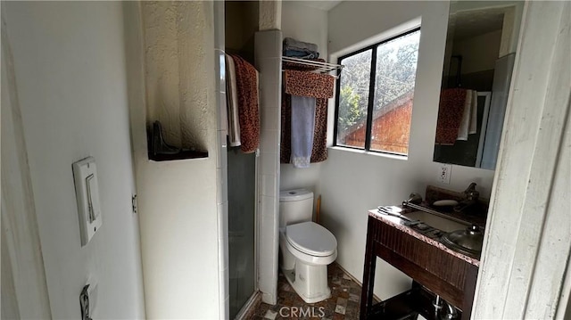 bathroom with a shower with door and toilet